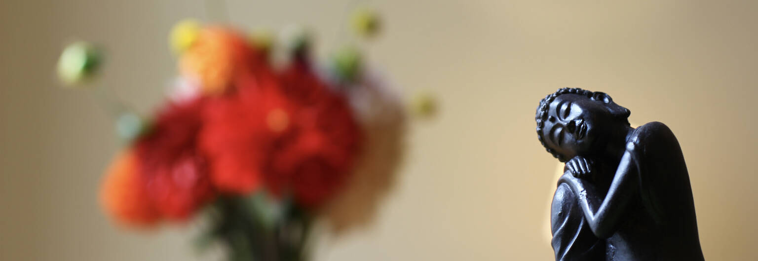 Buddhafigur mit Blumen in der Praxis
